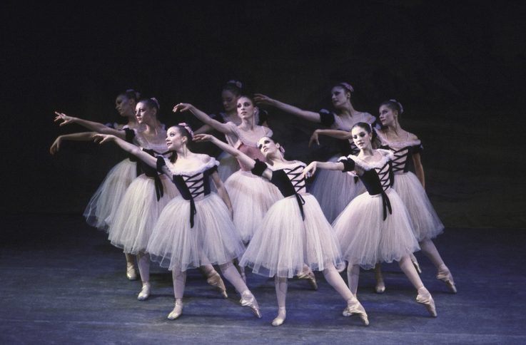 Kyra Nichols amidst a corps of dancers all reaching to the side of stage in tulle skirts in a performance of Scotch Symphony