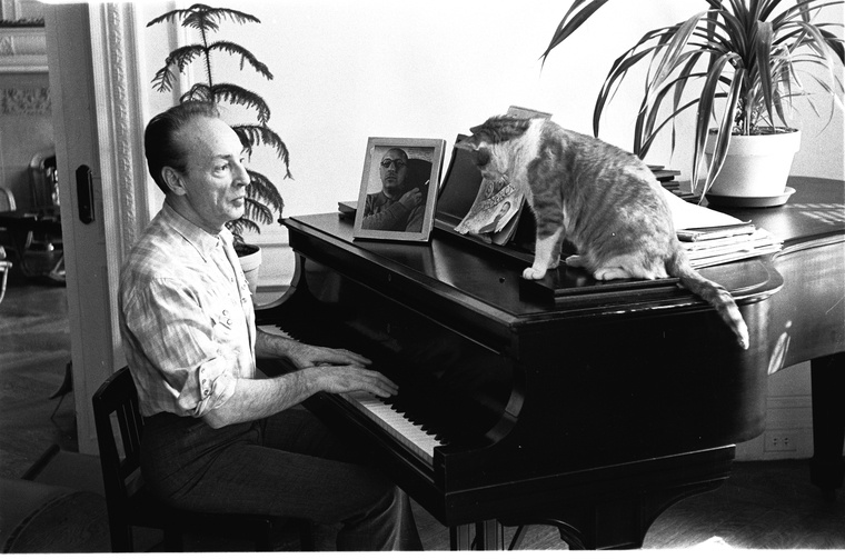 Balanchine sitting playing the piano at home with cat watching