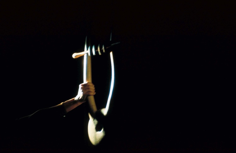 Hand holding an Orpheus lyre in the light, designed by Isamu Noguchi
